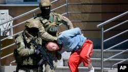 Bosnian Serb police escort a man suspected of links with Islamic extremists to court in the town of Banja Luka, Bosnia, May 8, 2015.