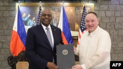 Menteri Pertahanan AS Lloyd Austin dan Menteri Pertahanan Filipina Gilberto Teodoro berpose usai menandatangani General Security of Military Information Agreement (GSOMIA) di Camp Aguinaldo, Quezon City, Metro Manila, pada 18 November. (Foto: AFP)