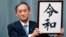 Japan’s Chief Cabinet Secretary Yoshihide Suga unveils the name of new era “Reiwa” at the prime minister’s office in Tokyo, Monday, April 1, 2019. 