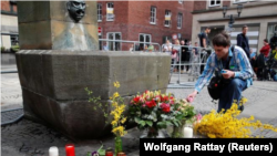 Un hombre coloca una vela en el lugar donde una camioneta embistió contra personas que estaban sentadas en las afueras de un popular restaurante en el centro de la ciudad vieja de Muenster, Alemania, 8 de abril, 2018. REUTERS/Wolfgang Rattay 