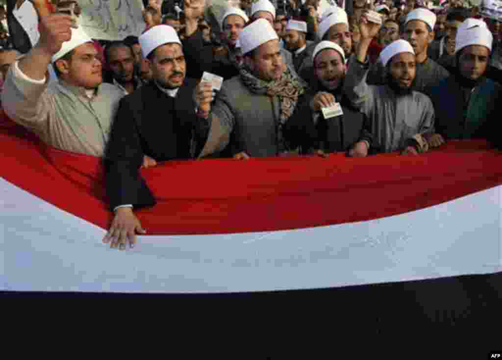 Clerics from Al Azhar Islamic university, some holding their identity cards, chant anti-government slogans during a protest in Tahrir, or Liberation, Square in Cairo, Egypt, Monday Jan. 31, 2011. A coalition of opposition groups called for a million peopl