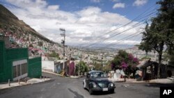 Janette Navarro maneja su Beetle Volkswagen de 1996 por una empinada colina del vecindario de Cuautepec, en Ciudad de México, el 21 de junio de 2024.