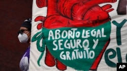 ARCHIVO - Una mujer sostiene una pancarta, mientras manifestantes por el derecho al aborto se manifiestan frente al Congreso Nacional en el "Día por la Despenalización del Aborto en América Latina y el Caribe", en la Ciudad de México. , 28 de septiembre de 2020.