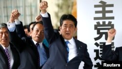 Japan's Prime Minister Shinzo Abe (3rd L) and his party's lawmakers raise their fists as they pledge to win in the upcoming lower house election, at their party headquarters in Tokyo, Japan September 28, 2017. 