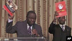 Zimbabwe Prime Minister and Movement For Democratic Change (MDC) leader Morgan Tsvangirai (L) and National Organising Secretary Nelson Chamisa present a booklet at the launch of Conditions for a Sustainable Election in Zimbabwe (COSEZ) in Harare, March 8