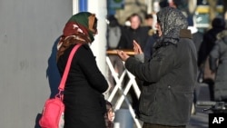 Two women talk in the so called "Mahgreb Quarter" in Duesseldorf, Germany, Jan. 19, 2016. Germany is still taking in around 2,000 refugees a day, but it is now denying entry to about 200 others daily at its borders, the country’s interior minister said on Jan. 24, 2016.