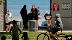 Signs are seen at Clark Street Beach during COVID-19 as people gather in Evanston, Ill., Tuesday, June 23, 2020. Gathering of up to 50 people will be allowed across the state starting Friday as Illinois moves into the fourth phase of its reopening…