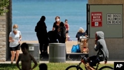 Signs are seen at Clark Street Beach during COVID-19 as people gather in Evanston, Ill., Tuesday, June 23, 2020. Gathering of up to 50 people will be allowed across the state starting Friday as Illinois moves into the fourth phase of its reopening…