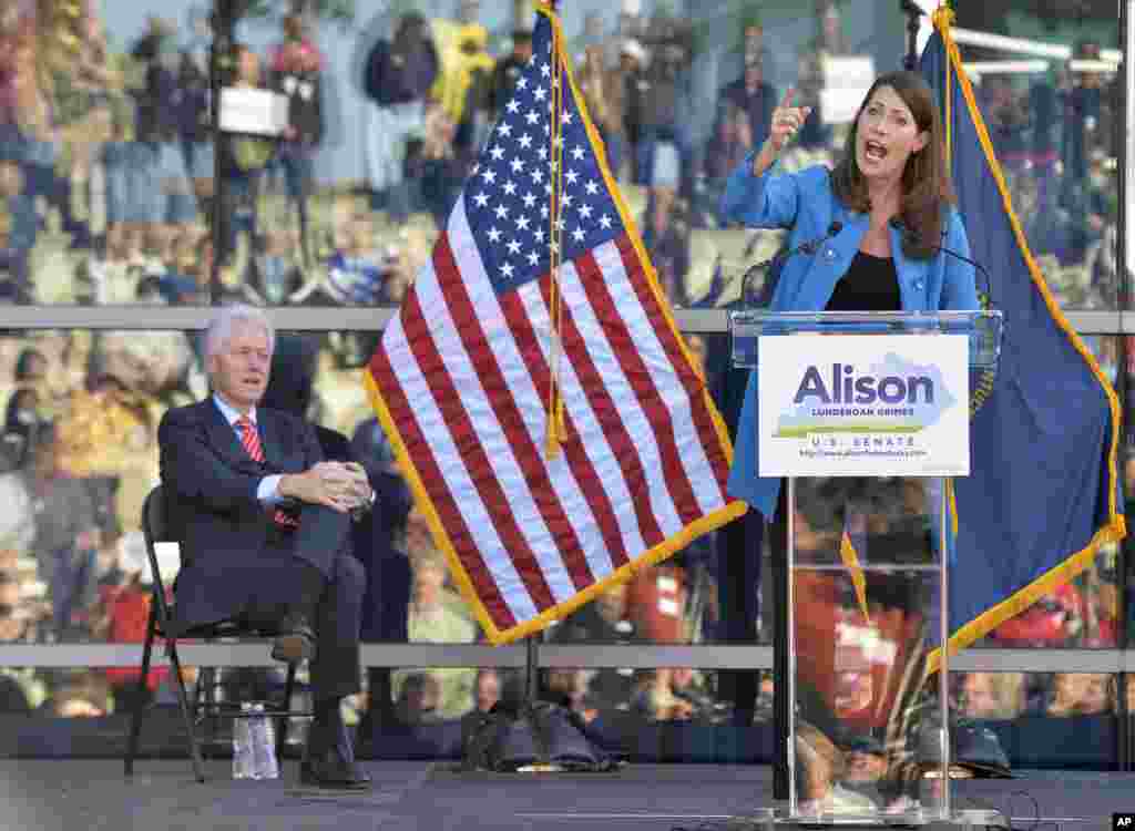With the crowd of supporters showing up in the windows behind her, Kentucky Democratic senatorial candidate Alison Lundergan Grimes, right, speaks as former President Bill Clinton looks on during a rally in Louisville, Kentucky, USA. 