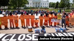 Activists wearing orange jumpsuits mark the 100th day of prisoners' hunger strike at Guantanamo Bay during a protest in front of the White House in Washington May 17, 2013. 