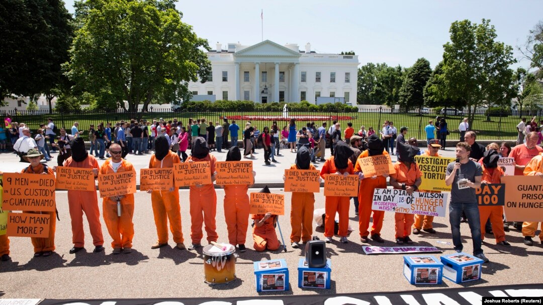 Para aktivis dengan mengenakan pakaian tahanan, menuntut penutupan pusat tahanan AS di Guantanamo, Kuba, dalam aksi protes di depan Gedung Putih (17/5).
