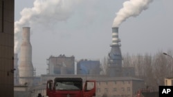 In this Dec. 30, 2016 photo, a truck leaves a sprawling complex that is a part of the Jiujiang steel and rolling mills in Qianan in northern China's Hebei province.