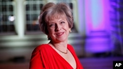 FILE - Britain's Prime Minister Theresa May poses for photographers upon arrival at The Sun Military Awards 2016 in London.