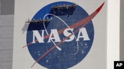 Arhiva - Radnici rade na fasadi sedišta NASA, u Svemirskom centru Kenedi, u Kejp Kanaveralu, Florida, 20. maja 2020.
