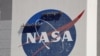 Para pekerja berada di dekat puncak gedung setinggi 526 kaki di Kennedy Space Center untk membersihkan logo NASA di Cape Canaveral, Florida, Rabu, 20 Mei 2020. (Foto: AP)