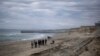 ARCHIVO - Varias personas caminan cerca del muro fronterizo entre Estados Unidos y México el sábado 25 de enero de 2025 en Tijuana, México. (Foto AP/Ethan Swope).