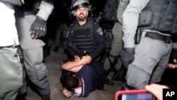 An Israeli police officer restrains a Palestinian during a protest ahead of a court verdict that may forcibly evict Palestinian families from their homes, in the Sheikh Jarrah neighborhood of East Jerusalem, May 5, 2021.