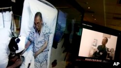 Video clips show China's jailed Nobel Peace laureate Liu Xiaobo lying on a bed receiving medical treatment at a hospital, left, and Liu saying wardens take good care of him, on a computer screens in Beijing, June 29, 2017.