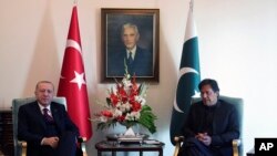 Turkey's President Recep Tayyip Erdogan, left, and Pakistan Prime Minister Imran Khan pose for photos before a meeting, in Islamabad, Pakistan, Feb. 14, 2020.