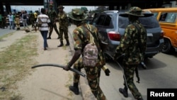 Nigerian security forces patrol as anti-government demonstrators march in the streets to protest bad governance and economic hardship, in Lagos, Nigeria, on Aug. 3, 2024.