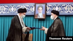 아야톨라 알리 하메네이 이란 최고지도자(왼쪽)가 3일 에브라힘 라이시 대통령 당선인(오른쪽)에게 임명장을 전달하고 있다.