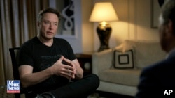 In this image released by FOX News, Elon Musk gestures as he is interviewed by FOX News host Tucker Carlson on Thursday, April 13, 2023. (FOX News via AP)