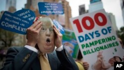 Un manifestante lleva una máscara de Donald Trump durante una protesta y marcha del "100 Días de Falla", el sábado 29 de abril de 2017, en Nueva York. 