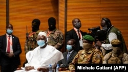 Le président de la transition malienne Bah Ndaw (à gauche) lors de sa prestation de serment au Centre International de Conférences de Bamako, le 25 septembre 2020. (Photo by Michele Cattani / AFP)