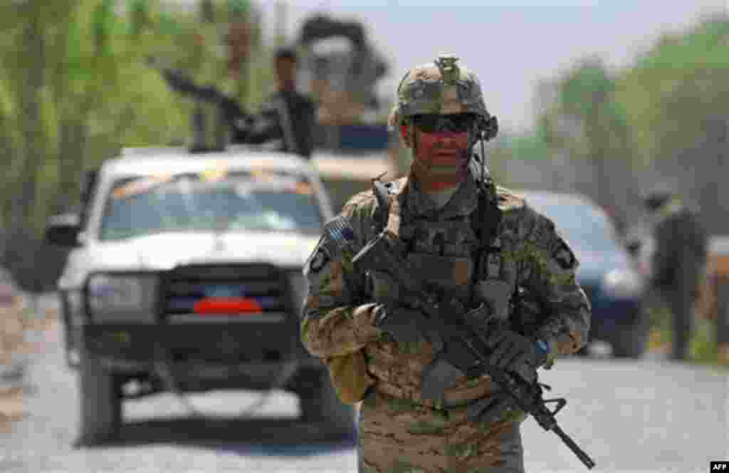 In this photo provided by ISAF Regional Command (South), a U.S. Army soldier patrols near near the village of Tarok Kolache, Friday, April 1, 2011, in the Arghandab River Valley of Afghanistan. Village elders and coalition forces held a ribbon cutting cer