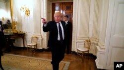 President Donald Trump gestures as he leaves a meeting with restaurant industry executives about the coronavirus response, in the State Dining Room of the White House, May 18, 2020, in Washington.