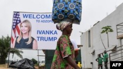 A woman walks past a sign with a portrait of Ivanka Trump before she takes part in the first West African summit on female entrepreneurship, in Adzope, north of Abidjan on April 17, 2019.