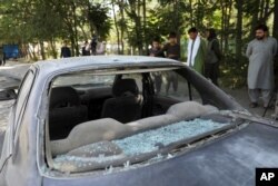 Sejumlah warga Afghanistan melihat mobil yang rusak setelah ledakan bom pinggir jalan di Kabul, Afghanistan, Minggu, 6 Juni 2021. (Foto: AP)