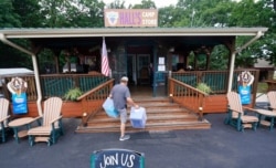 Mike Bond carries boxes as he prepares for the expected Memorial Day weekend visitors to Hall's Camp Store at the Vineyard Campground and Cabins on Grapevine Lake, May 28, 2021, in Grapevine, Texas.