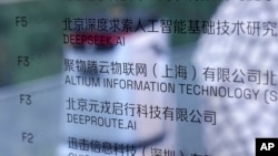 AI robot prolazi pored kancelarijske informativne table koja prikazuje kompaniju za aplikacije za pametne telefone DeepSeek u Pekingu, 28. januara 2025. Kina koristi Google-chetbot Gemini sa omogućenom vještačkom inteligencijom da pojača cyber napade na američke mete.