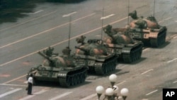 FILE - A Chinese man stands alone to block a line of tanks heading east on Beijing's Cangan Blvd. in Tiananmen Square in Beijing on June 5, 1989. 