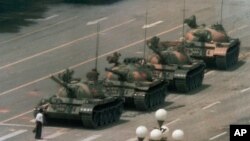 FILE - A Chinese man stands alone to block a line of tanks heading east on Beijing's Cangan Blvd. in Tiananmen Square in Beijing on June 5, 1989. 