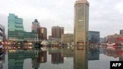 FILE - Baltimore, Maryland, is reflected in a still and icy Inner Harbor, Jan. 31, 2014. 